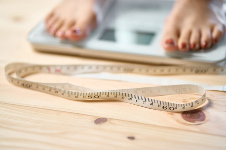 Feet of a woman on a measure and scale