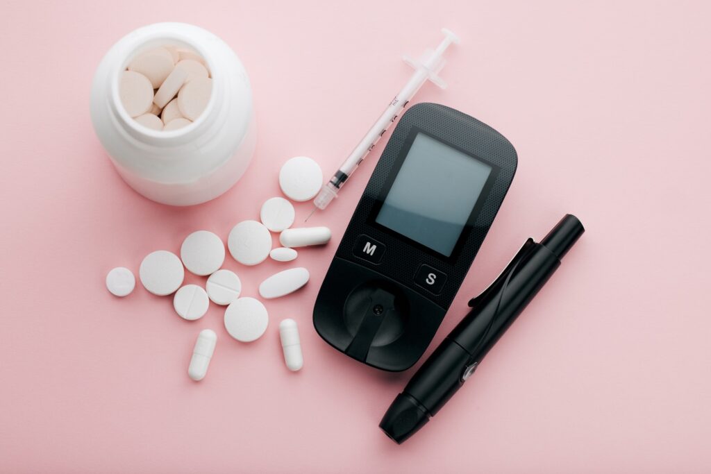 High angle shot of a blood glucose meter and pills in an empty studio