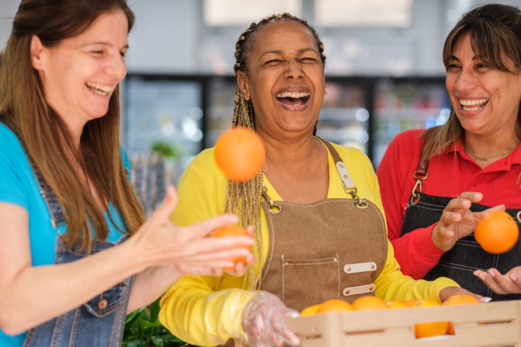 Middle-aged women carrying a crate of oranges