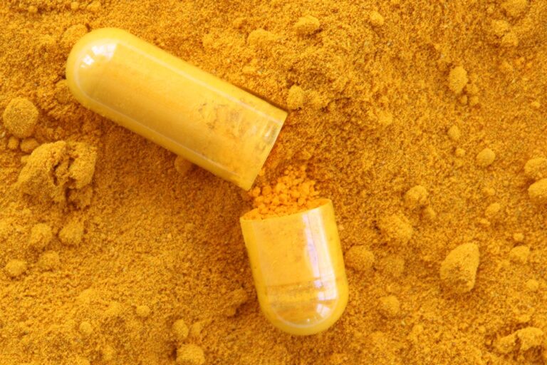 Curcumin capsule with pile of turmeric